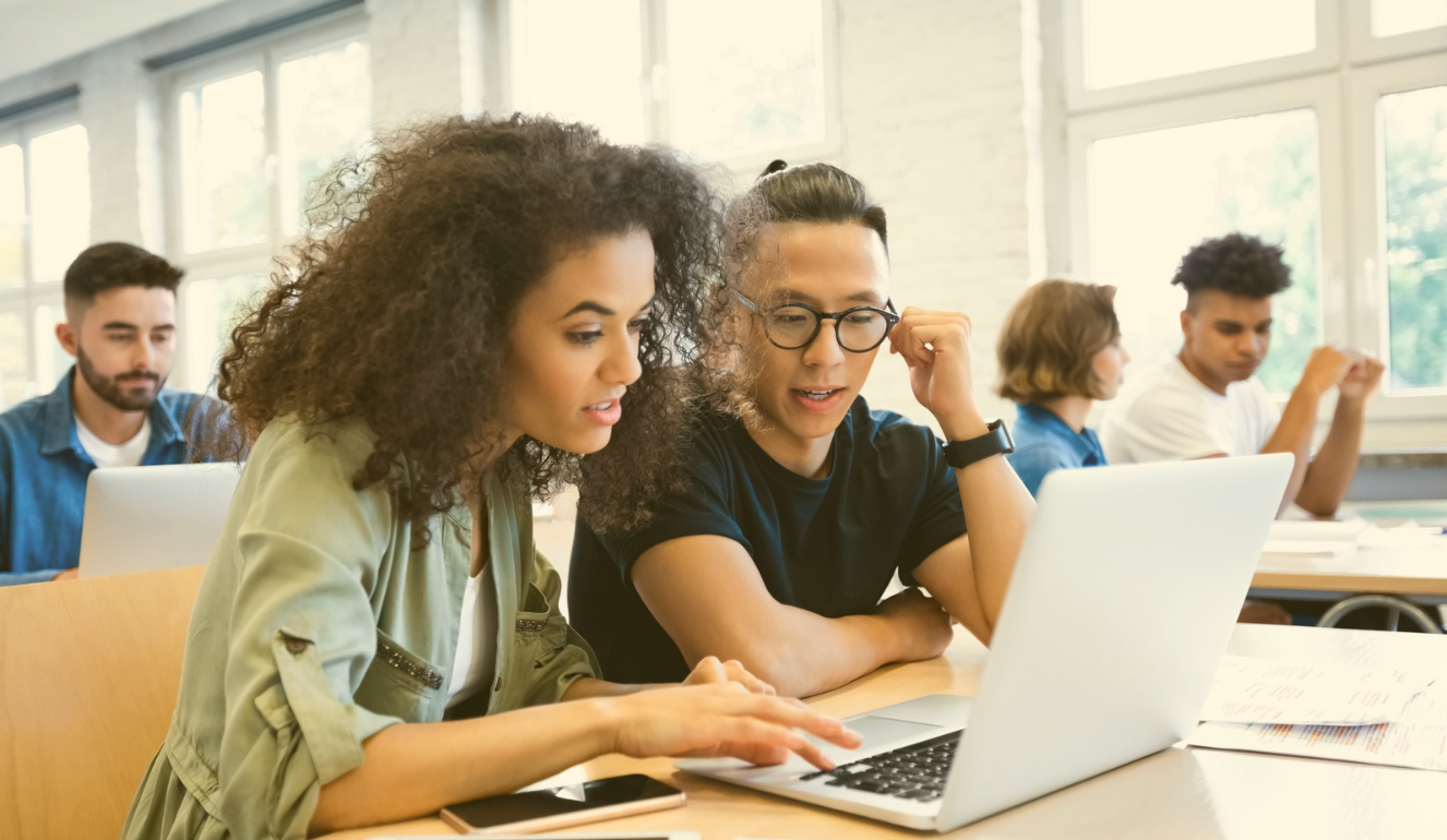 two people looking at a laptop